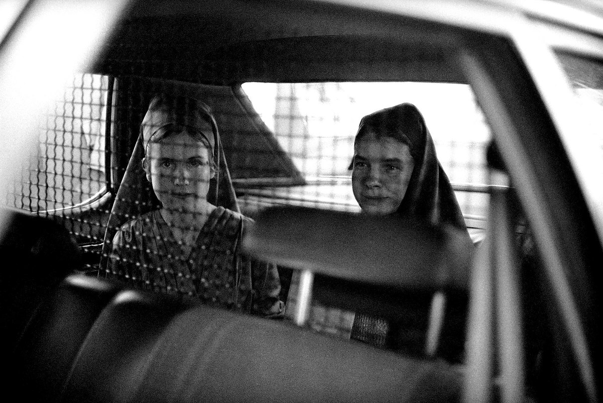 Члены "Семьи" Чарльза Мэнсона, Сандра Гуд (слева) и Сьюзен Мерфи за решеткой в автомобиле, на которой их забрали из Федерального суда в Сакраменто 14 апреля 1976 года после вынесения приговора. Г-жа Гуд была приговорена к 15 годам тюремного заключения в федеральной тюрьме, а г-жа Мерфи получила пять лет за сговор с целью угроз бизнесу и государственным должностным лицам